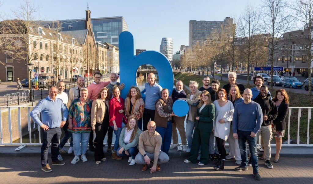 Het team van Buurkracht staat op een brug in Utrecht.