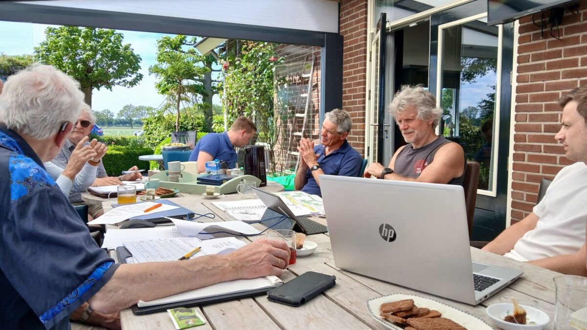 De buurtteams uit Beilen en Westerbork werken samen aan een tafel vol met papier en laptops.
