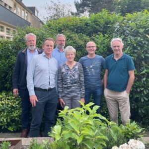Het buurtteam uit Vijfhuizen, bestaande uit 6 mensen, poseert in een groene achtertuin voor de camera.