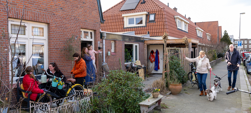 Een groep buren begroeten elkaar in hun straat in Utrecht.