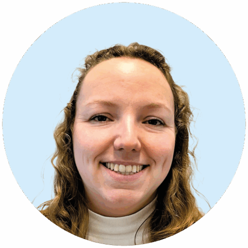 Portretfoto van Buurkracht buurtbegeleider Mosja, van schouders tot boven, genomen voor een lichtblauwe achtergrond.